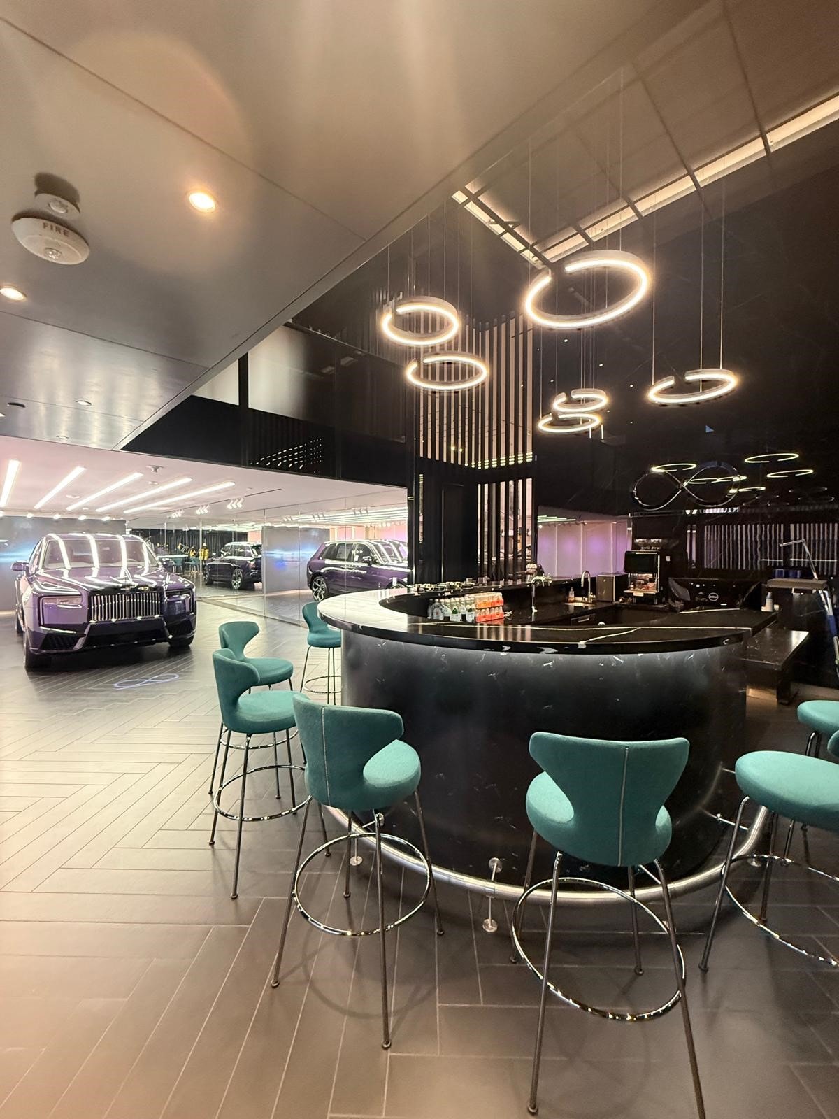 Rolls-Royce Beverly Hills client lounge with suspended ring lighting and hospitality bar
